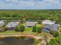 Overhead view of the property situated on a spacious lot with mature trees and a tranquil pond nearby at 16711 Rivers Reach Blvd, Parrish, FL 34219