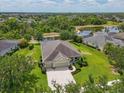Scenic aerial view of the property, nestled amongst mature trees, with a serene lake view in the background at 16711 Rivers Reach Blvd, Parrish, FL 34219