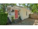 This charming home boasts a colorful front door, mature plants, and gravel landscaping at 1742 9Th St, Sarasota, FL 34236