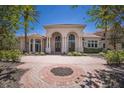 Elegant home with a grand entrance, arched doorways, and manicured landscaping at 19208 Ganton Ave, Lakewood Ranch, FL 34202