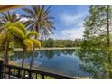 Picturesque view of a serene lake, lush trees, and reflections from a screened-in patio at 19208 Ganton Ave, Lakewood Ranch, FL 34202