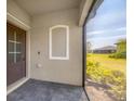 Outdoor porch with gray brick flooring and a screened-in area showcasing serene outdoor views at 2072 Mackerel St, Port Charlotte, FL 33953
