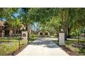 Grand entrance with a long driveway framed by mature trees, leading to a beautifully landscaped property at 222 High Point Dr, Venice, FL 34292