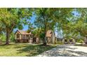 Elegant two-story home featuring a balcony, lush lawn, and a long driveway leading to a private retreat at 222 High Point Dr, Venice, FL 34292