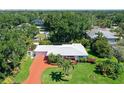 Beautiful aerial view of home showcasing lush landscaping, mature trees, and a spacious front yard at 2425 Calamonga Ln, Sarasota, FL 34239