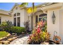 Charming front entrance with tropical landscaping, stone walkway and blue door at 356 Blackbird Ct, Bradenton, FL 34212