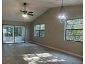 Spacious living room with vaulted ceiling, ceiling fan, pendant light, and sliding doors to the lanai at 3602 Bonaventure Ct, Sarasota, FL 34243