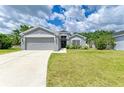 Inviting single-story home with a two-car garage, green lawn, and a charming front entrance with garden features at 4513 Abacos Pl, Bradenton, FL 34203