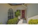 Home's attractive entry with mature, verdant landscaping, and arched accent window at 4691 Las Brisas Ln, Sarasota, FL 34238