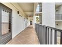 Exterior condo hallway with an exit sign, neutral paint color, and a black iron railing at 4800 Gulf Of Mexico Dr # 205, Longboat Key, FL 34228