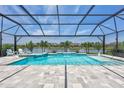 Screened-in pool and spa with a water feature overlooking a tranquil pond and manicured landscaping at 4975 Seafoam Trl, Bradenton, FL 34211