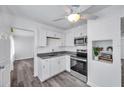 Clean, white kitchen with stainless steel appliances, granite countertops, and a view into the living area at 5214 11Th S Ave, Gulfport, FL 33707