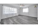 Spacious living room with wood-look floors, sheer curtains, and ample natural light from large windows at 5214 11Th S Ave, Gulfport, FL 33707