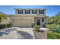 Two-story home with a two-car garage, manicured landscaping, and a covered front porch at 5403 Mang Pl, Sarasota, FL 34238