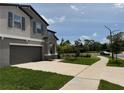 Well-maintained two-story home with an attached two-car garage and manicured front lawn at 5430 Amaryllis Garden St, Apollo Beach, FL 33572