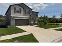 Two-story home with a wide driveway, well-kept lawn, and tasteful landscaping at 5430 Amaryllis Garden St, Apollo Beach, FL 33572