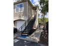Side view of a beige condo unit with stairs and black metal railings at 5741 Soldier Cir # 202, Sarasota, FL 34233