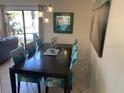 Dining area with seating for six, modern light fixture, and a large glass door at 6157 E Midnight Pass Rd # B51, Sarasota, FL 34242