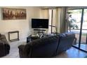 Comfortable living room with a TV and access to outdoor patio at 6157 E Midnight Pass Rd # B51, Sarasota, FL 34242