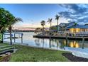 Picturesque evening view of the private dock with a boat lift, providing easy access to the water at 621 Ivanhoe Ln, Holmes Beach, FL 34217