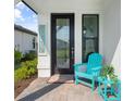 A welcoming front door with a decorative teal chair and table to invite you to come inside at 6248 Fish Eagle Ct, Nokomis, FL 34275