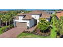 Attractive single-Gathering home featuring a tile roof, attached garage, brick driveway, and meticulous landscaping at 6290 Mesa Gln, Bradenton, FL 34203