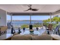 Spacious outdoor porch with ceiling fan, comfortable seating, and panoramic waterfront views at 7985 Manasota Key Rd, Englewood, FL 34223