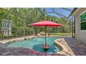 Screened-in pool featuring a rock waterfall, seating area, and lush greenery surrounding the backyard oasis at 8019 Indigo Ridge Ter, Bradenton, FL 34201