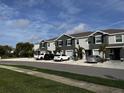 A row of gray townhomes, each with a one car garage and simple landscaping at 8864 Milestone Dr, Sarasota, FL 34238