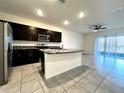 Kitchen with dark cabinetry, granite countertops, stainless steel appliances, and a center island at 8864 Milestone Dr, Sarasota, FL 34238