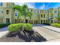 Attractive green townhouse showcasing individual driveways, garage doors, and tropical landscaping at 8943 White Sage Loop, Lakewood Ranch, FL 34202