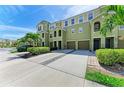 Inviting two-story townhomes with attached garages, well-maintained landscaping, and ample parking on a sunny day at 8943 White Sage Loop, Lakewood Ranch, FL 34202