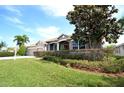 Charming single-story house with manicured lawn, vibrant shrubbery, and an elegant entryway at 9112 63Rd E Ct, Parrish, FL 34219