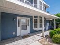 Inviting front porch with wood-look tile, a covered entryway, and charming details accentuating the blue exterior at 1310 91St Nw Ct, Bradenton, FL 34209