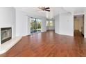 Bright living room featuring tile floors, a cozy fireplace, a ceiling fan, and sliding glass doors to the outside at 1310 91St Nw Ct, Bradenton, FL 34209