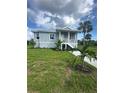 Inviting home featuring a porch, new landscaping, and a healthy green lawn at 14343 Myakka Ave, Port Charlotte, FL 33953