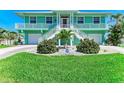 Charming two-story waterfront home with a lush green lawn, meticulously kept landscaping, and a two-car garage at 1918 Massachusetts Ave, Englewood, FL 34224