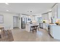 Bright kitchen featuring white cabinets, stainless steel appliances, a center island, and tile flooring at 2111 Ivory Pl, Sarasota, FL 34239