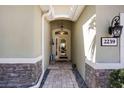 Inviting front entry featuring stone accents, a covered porch, and a glass front door at 2239 Ellarose Cir, Sarasota, FL 34232