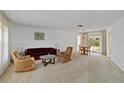 Spacious living room features neutral carpet and ample seating, dining table, and natural light at 2271 Pine View Cir, Sarasota, FL 34231