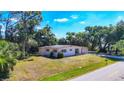 A charming single-story home featuring a well-maintained lawn and lush greenery, providing a serene curb appeal at 2538 Lakeshore Cir, Port Charlotte, FL 33952