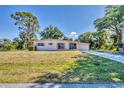 Attractive home with a manicured lawn, long driveway, and traditional shutters adding curb appeal at 2538 Lakeshore Cir, Port Charlotte, FL 33952