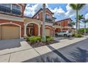 Attractive exterior view of a townhome with private garage and lush tropical landscaping at 288 Crew Ct, Sarasota, FL 34243