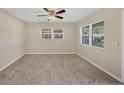A view of an empty bedroom with neutral colors, tile floors, and natural light at 2947 Goodrich Ave, Sarasota, FL 34234