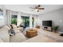 Cozy living room with modern furnishings, neutral tones, ceiling fan, and access to outdoor patio at 2950 Clark Rd # 113, Sarasota, FL 34231
