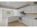 Open kitchen with white cabinets, tile floors, and a breakfast bar at 3505 27Th W Ave, Bradenton, FL 34205