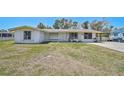 Quaint single-story home with a well-maintained front lawn, carport, and a classic white facade at 4420 101St W St, Bradenton, FL 34210