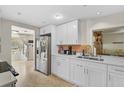 Modern kitchen featuring white cabinets, stainless steel appliances, and an adjacent dining area at 4420 101St W St, Bradenton, FL 34210