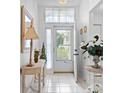 Bright foyer with white tile flooring, decorative mirror, and glass front door at 4610 Runabout Way, Bradenton, FL 34203