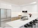 A modern kitchen featuring white cabinets, stainless steel appliances, and a stylish marble countertop with seating at 4950 Remington Dr # 114, Sarasota, FL 34234